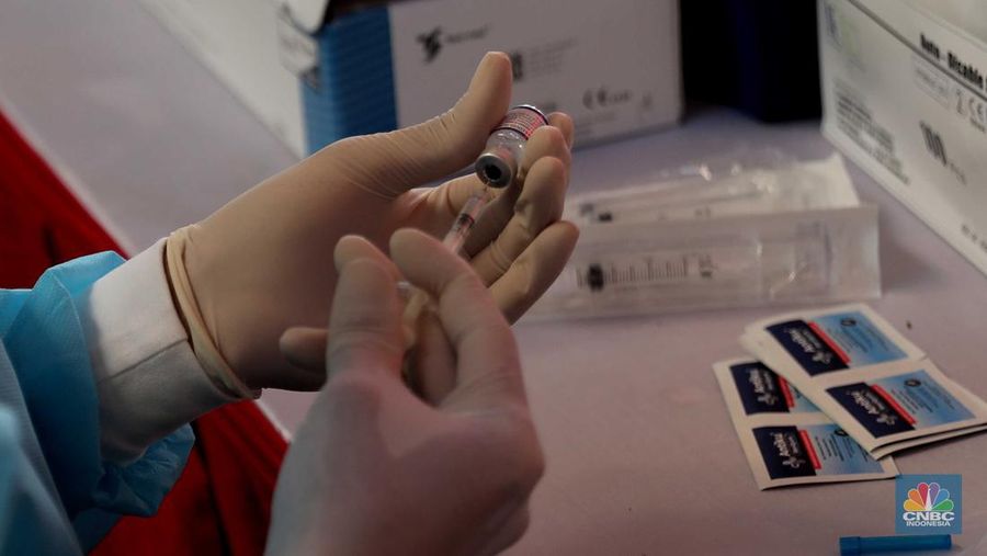 Petugas menyuntikkan vaksin Covid-19 dosis ketiga (booster) di Lobby Pasar Induk Kramat Jati, Jakarta, Rabu, 6 April 2022. (CNBC Indonesia/Muhammad Sabki)