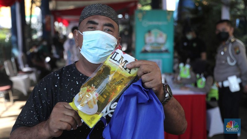 Petugas menyuntikkan vaksin Covid-19 dosis ketiga (booster) di Lobby Pasar Induk Kramat Jati, Jakarta, Rabu, 6 April 2022. (CNBC Indonesia/Muhammad Sabki)
