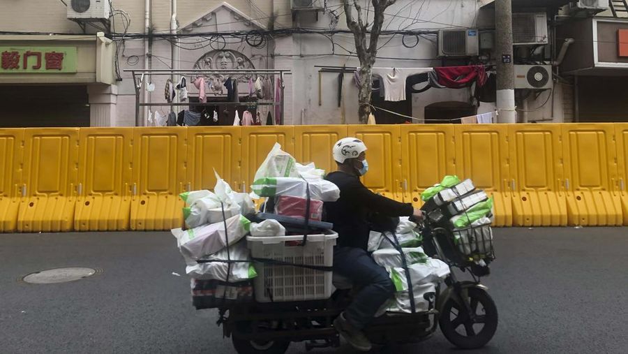 Kurir mengantarkan logistik untuk warga yang terkena lockdown di Shanghai, China. (AP/Chen Si)