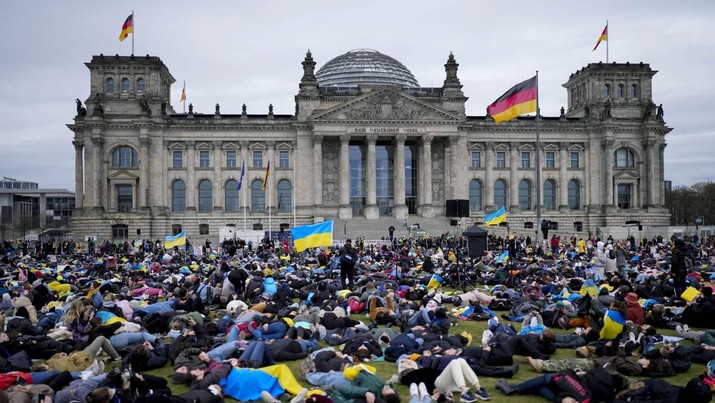 Orang-orang berbaring di tanah untuk melambangkan orang-orang yang tewas dalam perang di Ukraina selama demonstrasi menentang invasi Rusia ke Ukraina, di depan gedung Reichstag di Berlin, Jerman, Rabu, 6 April 2022. (AP/Markus Schreiber)