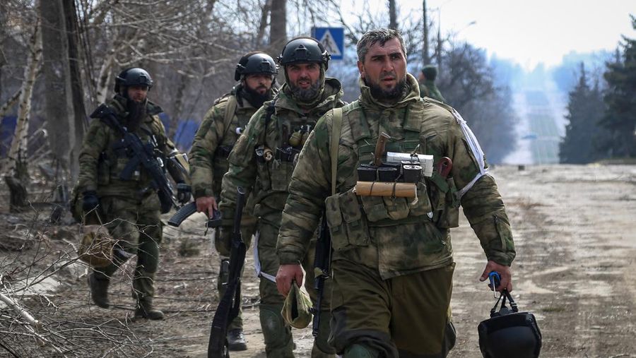 Anggota dinas dari Republik Chechnya berjalan selama pertempuran dalam konflik Ukraina-Rusia di kota Mariupol, Ukraina. (REUTERS/STRINGER)