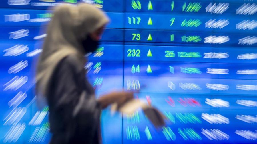 Pekerja berjalan dengan latar belakang layar pergerakan harga saham di gedung Bursa Efek Indonesia, Jakarta, Jumat (8/4/2022). Indeks Harga Saham Gabungan (IHSG) hari Jumat (8/4) sore ditutup naik 83,46 poin atau 1,17 persen menembus level 7.210. ANTARA FOTO/Muhammad Adimaja/wsj.