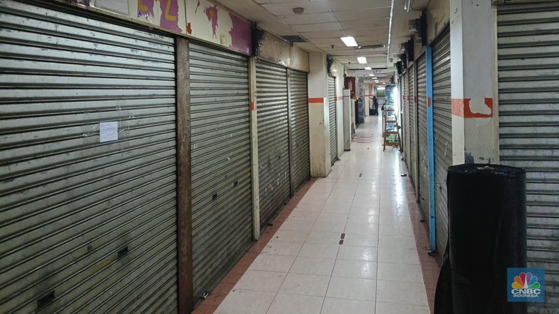 Pengunjung melewati ruko yang bertuliskan 