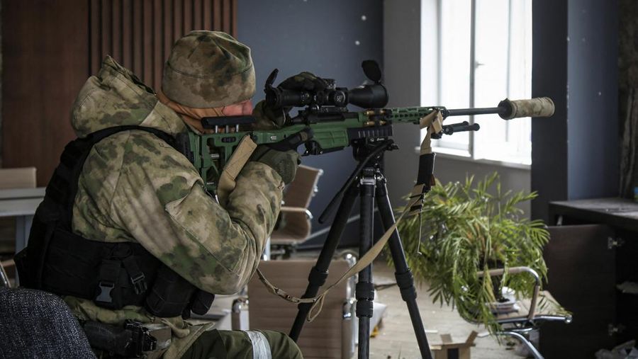 Seorang anggota militer dari Republik Chechnya mengarahkan senapannya selama pertempuran dalam konflik Ukraina-Rusia di kota Mariupol, Ukraina. (REUTERS/STRINGER)