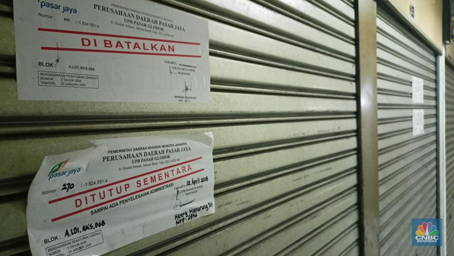 Pengunjung melewati ruko yang bertuliskan 