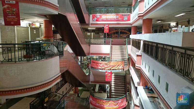 Pengunjung melewati ruko yang bertuliskan 