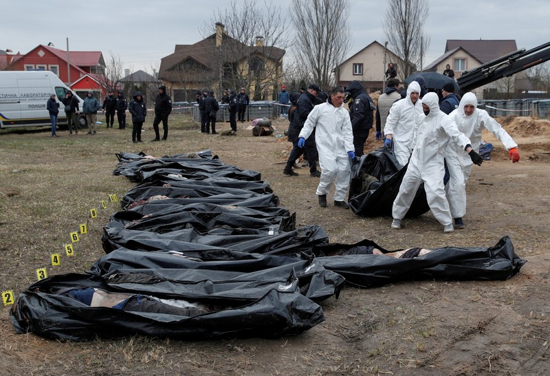 Tim forensik menggali mayat warga sipil yang menurut pejabat Ukraina tewas saat serangan Rusia  dan kemudian dimakamkan di kuburan massal di kota Bucha, di luar Kyiv, Ukraina, Jumat (8/4/2022). (REUTERS/Valentyn Ogirenko)