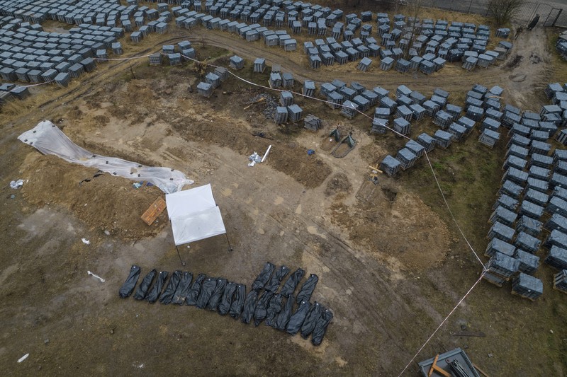 Tim forensik menggali mayat warga sipil yang menurut pejabat Ukraina tewas saat serangan Rusia  dan kemudian dimakamkan di kuburan massal di kota Bucha, di luar Kyiv, Ukraina, Jumat (8/4/2022). (REUTERS/Valentyn Ogirenko)