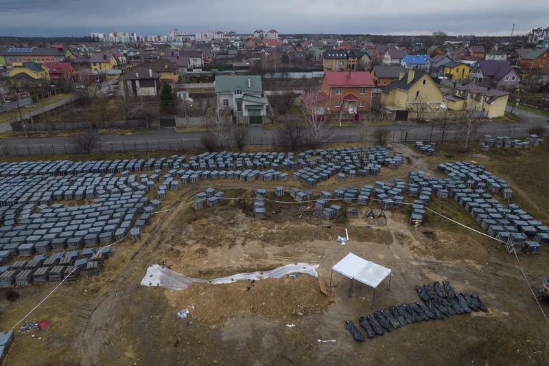 Tim forensik menggali mayat warga sipil yang menurut pejabat Ukraina tewas saat serangan Rusia  dan kemudian dimakamkan di kuburan massal di kota Bucha, di luar Kyiv, Ukraina, Jumat (8/4/2022). (REUTERS/Valentyn Ogirenko)