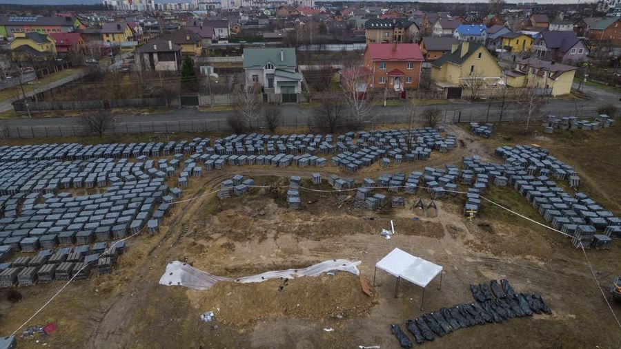Tim forensik menggali mayat warga sipil yang menurut pejabat Ukraina tewas saat serangan Rusia  dan kemudian dimakamkan di kuburan massal di kota Bucha, di luar Kyiv, Ukraina, Jumat (8/4/2022). (REUTERS/Valentyn Ogirenko)