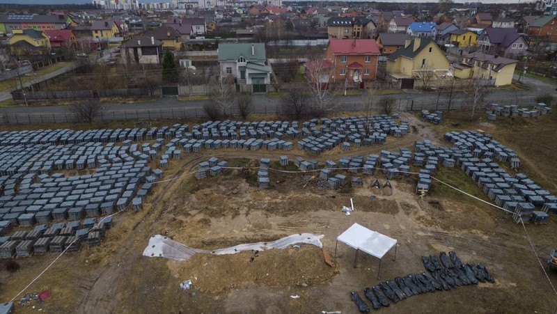 Tim forensik menggali mayat warga sipil yang menurut pejabat Ukraina tewas saat serangan Rusia  dan kemudian dimakamkan di kuburan massal di kota Bucha, di luar Kyiv, Ukraina, Jumat (8/4/2022). (REUTERS/Valentyn Ogirenko)