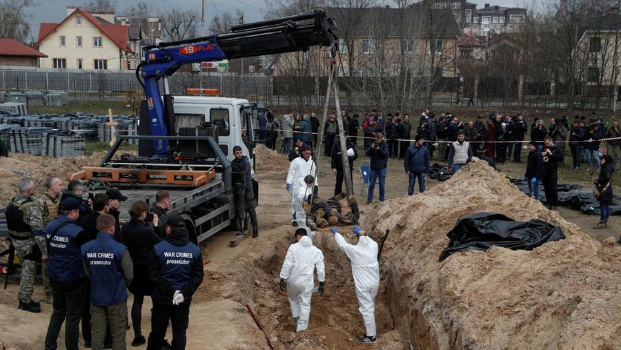 Tim forensik menggali mayat warga sipil yang menurut pejabat Ukraina tewas saat serangan Rusia  dan kemudian dimakamkan di kuburan massal di kota Bucha, di luar Kyiv, Ukraina, Jumat (8/4/2022). (REUTERS/Valentyn Ogirenko)