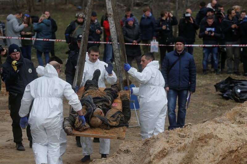 Tim forensik menggali mayat warga sipil yang menurut pejabat Ukraina tewas saat serangan Rusia  dan kemudian dimakamkan di kuburan massal di kota Bucha, di luar Kyiv, Ukraina, Jumat (8/4/2022). (REUTERS/Valentyn Ogirenko)