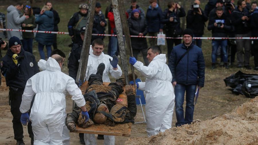 Tim forensik menggali mayat warga sipil yang menurut pejabat Ukraina tewas saat serangan Rusia  dan kemudian dimakamkan di kuburan massal di kota Bucha, di luar Kyiv, Ukraina, Jumat (8/4/2022). (REUTERS/Valentyn Ogirenko)