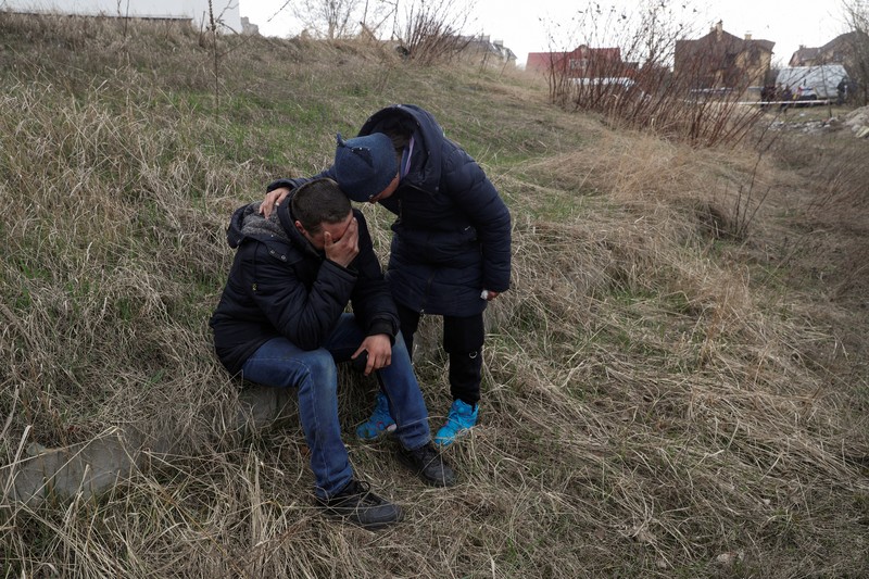 Tim forensik menggali mayat warga sipil yang menurut pejabat Ukraina tewas saat serangan Rusia  dan kemudian dimakamkan di kuburan massal di kota Bucha, di luar Kyiv, Ukraina, Jumat (8/4/2022). (REUTERS/Valentyn Ogirenko)