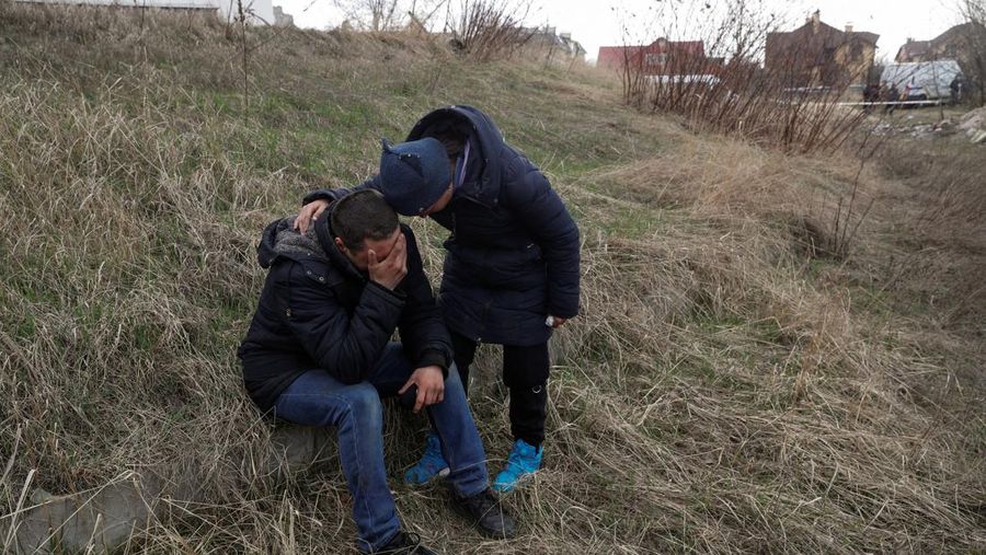 Tim forensik menggali mayat warga sipil yang menurut pejabat Ukraina tewas saat serangan Rusia  dan kemudian dimakamkan di kuburan massal di kota Bucha, di luar Kyiv, Ukraina, Jumat (8/4/2022). (REUTERS/Valentyn Ogirenko)