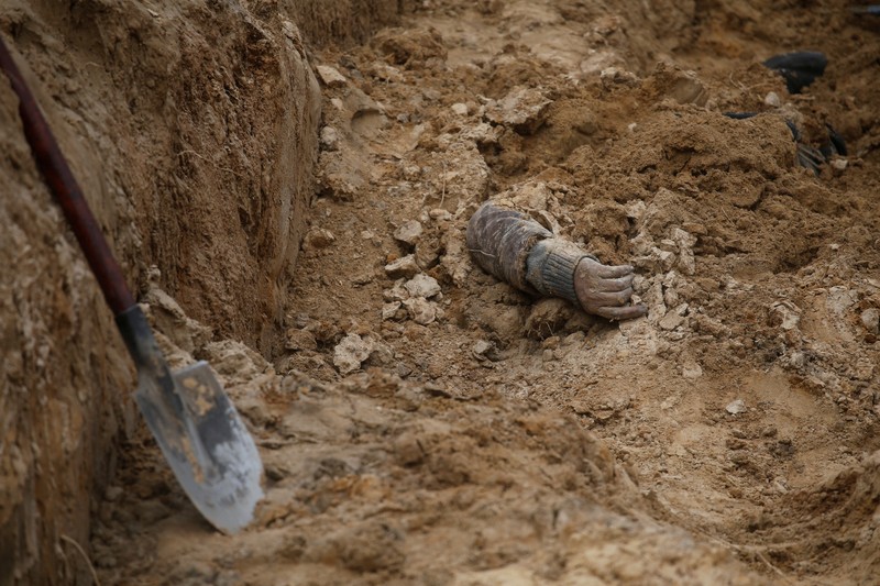 Kuburan Massal Warga Spil Ukraina di Bucha, di wilayah Kyiv, Ukraina, Tim forensik menggali mayat warga sipil yang menurut pejabat Ukraina tewas saat serangan Rusia dan kemudian dimakamkan di kuburan massal di kota Bucha, di luar Kyiv, Ukraina, Jumat (8/4/2022). (REUTERS/Valentyn Ogirenko)