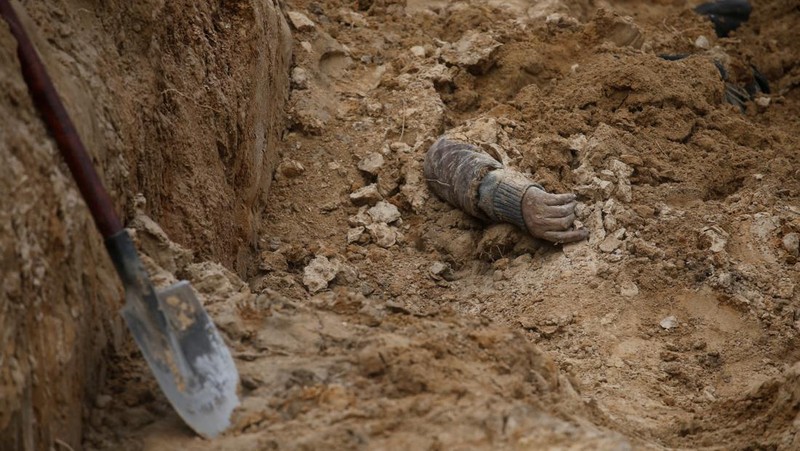 Tim forensik menggali mayat warga sipil yang menurut pejabat Ukraina tewas saat serangan Rusia  dan kemudian dimakamkan di kuburan massal di kota Bucha, di luar Kyiv, Ukraina, Jumat (8/4/2022). (REUTERS/Valentyn Ogirenko)