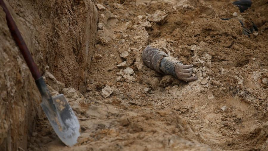Tangan seorang warga sipil yang menurut pejabat Ukraina tewas saat serangan Rusia terlihat di kuburan massal di kota Bucha, di luar Kyiv, Ukraina, Jumat (8/4/2022). (REUTERS/Valentyn Ogirenko)