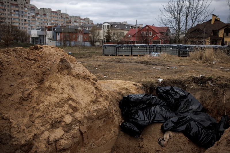 Tim forensik menggali mayat warga sipil yang menurut pejabat Ukraina tewas saat serangan Rusia  dan kemudian dimakamkan di kuburan massal di kota Bucha, di luar Kyiv, Ukraina, Jumat (8/4/2022). (REUTERS/Valentyn Ogirenko)