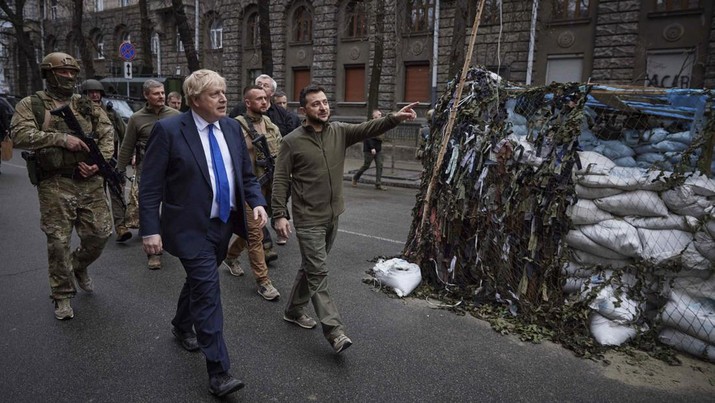 Presiden Ukraina Volodymyr Zelensky (tengah) dan Perdana Menteri Inggris Boris Johnson, (kiri tengah) berjalan saat kunjungannya di pusat kota Kyiv, Ukraina, Sabtu (9/4/2022). (Ukrainian Presidential Press Office via AP)