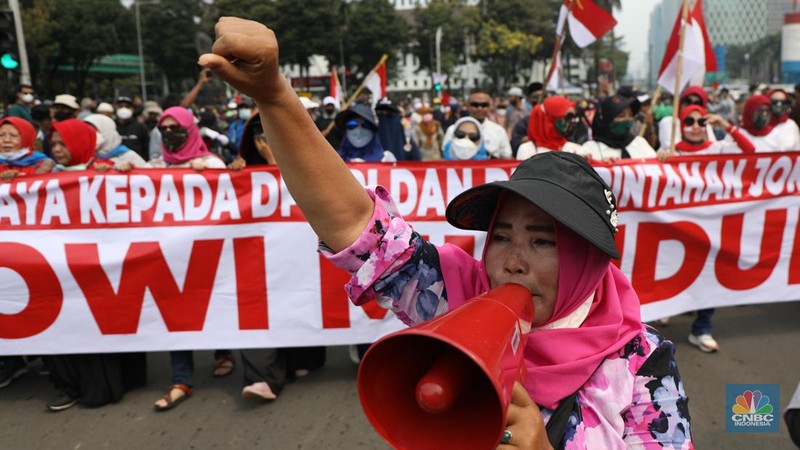 Ratusan pengunjuk rasa kaum perempuan membentangkan spanduk di Patung Kuda, Jakarta, Senin (11/4/2022). (CNBC Indonesia/ Tri Susilo)