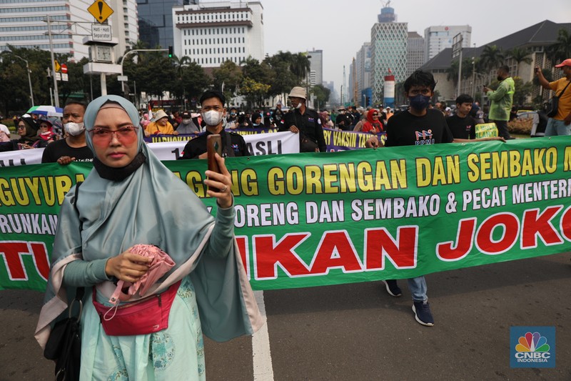 Ratusan pengunjuk rasa kaum perempuan membentangkan spanduk di Patung Kuda, Jakarta, Senin (11/4/2022). (CNBC Indonesia/ Tri Susilo)