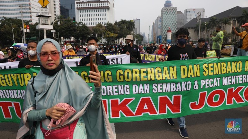 Ratusan pengunjuk rasa kaum perempuan membentangkan spanduk di Patung Kuda, Jakarta, Senin (11/4/2022). (CNBC Indonesia/ Tri Susilo)