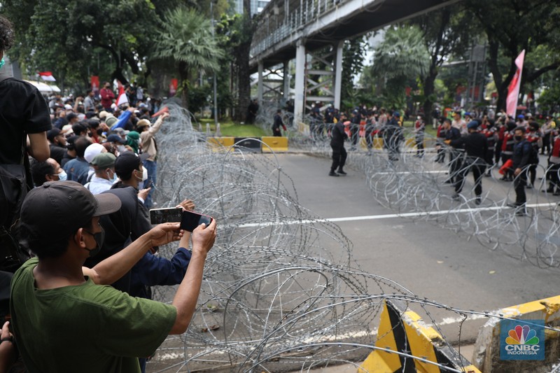 Demo di Kawasan Patung Kuda Ratusan pengunjuk rasa kaum perempuan membentangkan spanduk di Patung Kuda, Jakarta, Senin (11/4/2022). (CNBC Indonesia/ Tri Susilo)