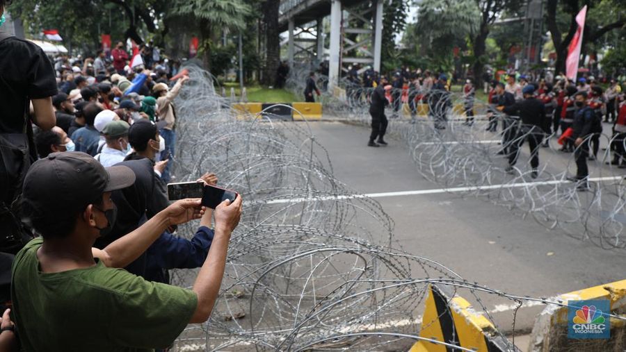 Ratusan pengunjuk rasa kaum perempuan membentangkan spanduk di Patung Kuda, Jakarta, Senin (11/4/2022). (CNBC Indonesia/ Tri Susilo)