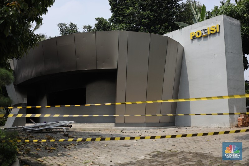 Petugas memeriksa pos polisi subsektor Pejompongan, Polsek Tanah Abang, Jakarta Pusat, Selasa (12/4/2022). Pos polisi  tersebut dibakar oleh orang tak dikenal usai kericuhan demo pada Senin (11/4/2022). ((CNBC Indonesia/ Tri Susilo)