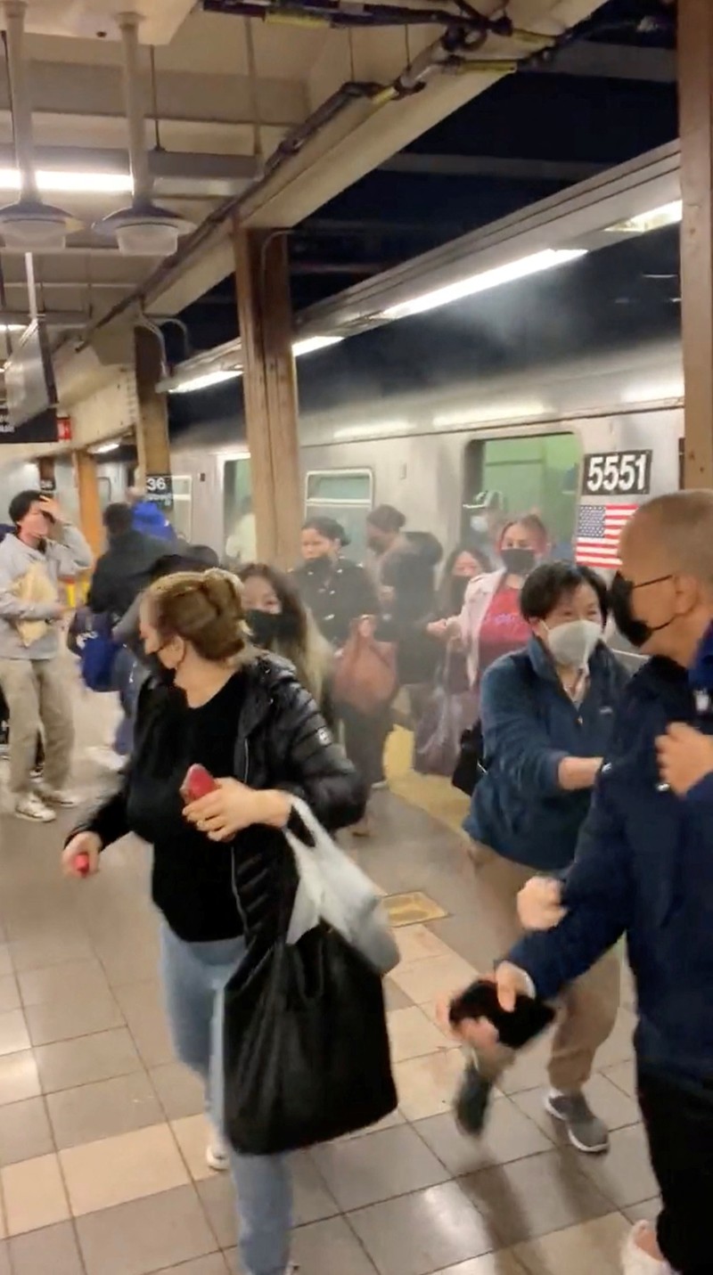 Penembakan di kereta bawah tanah di New York City, Amerika Serikat Penumpang membantu korban penembakan di luar gerbong kereta bawah tanah di wilayah Brooklyn di New York, Selasa (12/4/2022). Sejumlah penumpang diberondong tembakan pria tak dikenal di kereta bawah tanah di New York City saat jam sibuk pagi hari yang menyebabkan penumpang terluka berdarah di peron kereta. (Will B Wylde via AP)