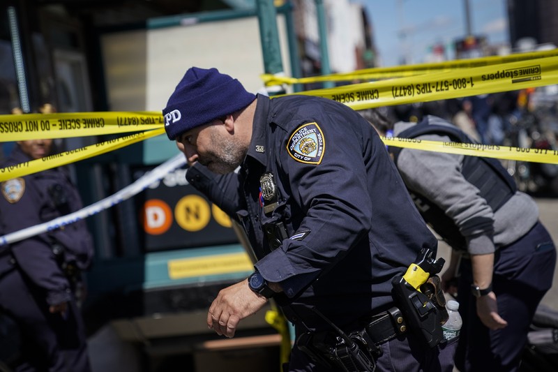 Penembakan di kereta bawah tanah di New York City, Amerika Serikat Penumpang membantu korban penembakan di luar gerbong kereta bawah tanah di wilayah Brooklyn di New York, Selasa (12/4/2022). Sejumlah penumpang diberondong tembakan pria tak dikenal di kereta bawah tanah di New York City saat jam sibuk pagi hari yang menyebabkan penumpang terluka berdarah di peron kereta. (Will B Wylde via AP)