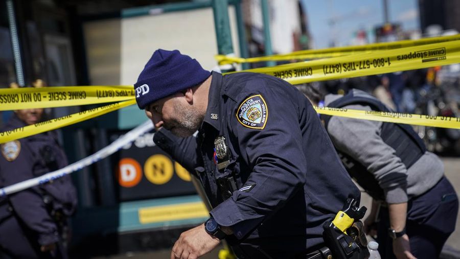 Penumpang membantu korban penembakan di luar gerbong kereta bawah tanah di wilayah Brooklyn di New York, Selasa (12/4/2022).  Sejumlah penumpang diberondong tembakan pria tak dikenal di kereta bawah tanah di New York City saat jam sibuk pagi hari yang menyebabkan penumpang terluka berdarah di peron kereta. (Will B Wylde via AP)