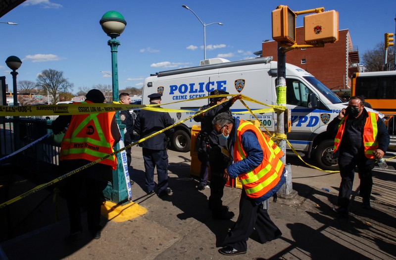 Penumpang membantu korban penembakan di luar gerbong kereta bawah tanah di wilayah Brooklyn di New York, Selasa (12/4/2022).  Sejumlah penumpang diberondong tembakan pria tak dikenal di kereta bawah tanah di New York City saat jam sibuk pagi hari yang menyebabkan penumpang terluka berdarah di peron kereta. (Will B Wylde via AP)