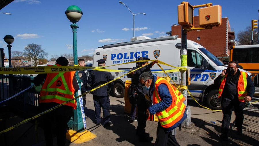 Penumpang membantu korban penembakan di luar gerbong kereta bawah tanah di wilayah Brooklyn di New York, Selasa (12/4/2022).  Sejumlah penumpang diberondong tembakan pria tak dikenal di kereta bawah tanah di New York City saat jam sibuk pagi hari yang menyebabkan penumpang terluka berdarah di peron kereta. (Will B Wylde via AP)