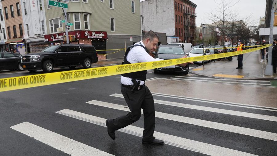 Penumpang membantu korban penembakan di luar gerbong kereta bawah tanah di wilayah Brooklyn di New York, Selasa (12/4/2022).  Sejumlah penumpang diberondong tembakan pria tak dikenal di kereta bawah tanah di New York City saat jam sibuk pagi hari yang menyebabkan penumpang terluka berdarah di peron kereta. (Will B Wylde via AP)