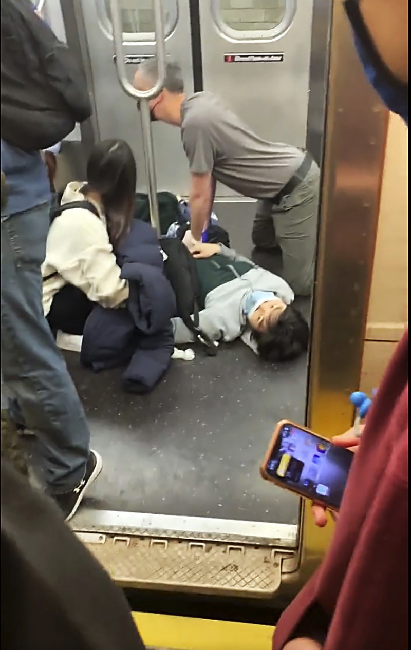 Penembakan di kereta bawah tanah di New York City, Amerika Serikat Penumpang membantu korban penembakan di luar gerbong kereta bawah tanah di wilayah Brooklyn di New York, Selasa (12/4/2022). Sejumlah penumpang diberondong tembakan pria tak dikenal di kereta bawah tanah di New York City saat jam sibuk pagi hari yang menyebabkan penumpang terluka berdarah di peron kereta. (Will B Wylde via AP)
