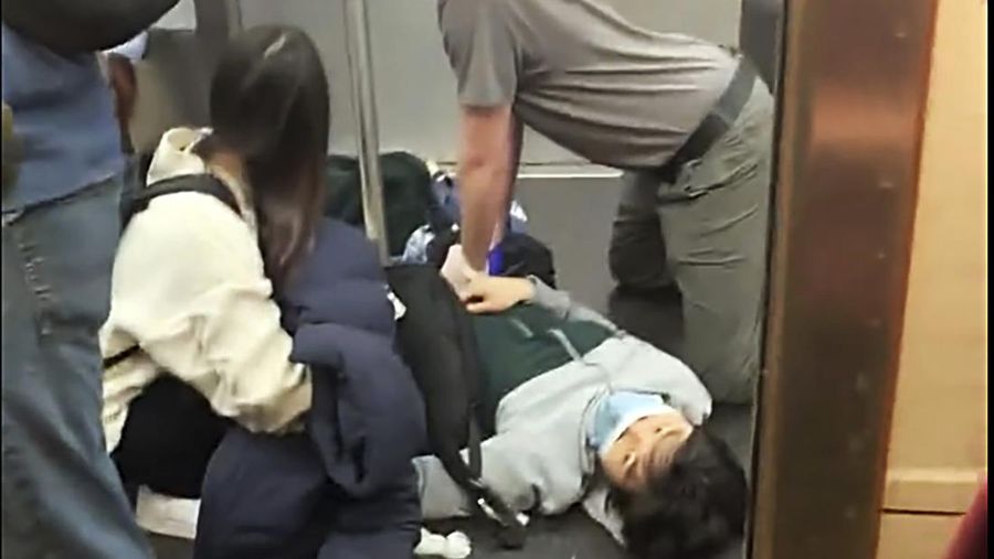 Penumpang membantu korban penembakan di luar gerbong kereta bawah tanah di wilayah Brooklyn di New York, Selasa (12/4/2022).  Sejumlah penumpang diberondong tembakan pria tak dikenal di kereta bawah tanah di New York City saat jam sibuk pagi hari yang menyebabkan penumpang terluka berdarah di peron kereta. (Will B Wylde via AP)