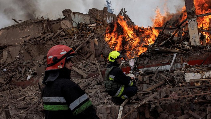 Petugas pemadam kebakaran bekerja di gedung yang terbakar akibat serangan rudal di dekat Bandara Internasional Kharkiv, saat serangan Rusia di Ukraina berlanjut, di Kharkiv, Ukraina, Rabu (12/4/2022). Otoritas Ukraina melaporkan pasukan Rusia kembali menggempur kota Kharkiv, yang merupakan kota terbesar kedua di negara tersebut yang mengakibatkan tujuh orang tewas dan 22 orang lainnya mengalami luka-luka akibat gempuran itu. (REUTERS/Alkis Konstantinidis)