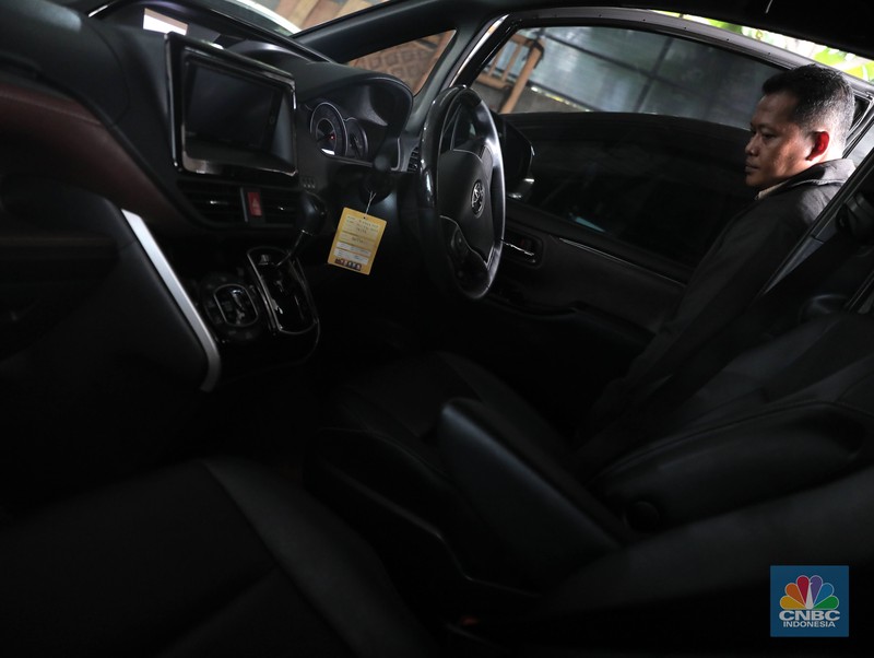 Pekerja  mengecek kendraan yang akan di rentalkan di pool penyewaan rental mobil Sembodo Rentcar di Kawasan Jakarta, Rabu, (13/4/2022). (CNBC Indonesia/ Muhammad Sabki)