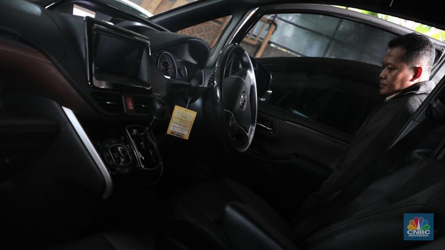 Pekerja  mengecek kendraan yang akan di rentalkan di pool penyewaan rental mobil Sembodo Rentcar di Kawasan Jakarta, Rabu, (13/4/2022). (CNBC Indonesia/ Muhammad Sabki)