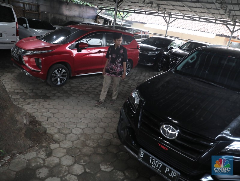 Pekerja  mengecek kendraan yang akan di rentalkan di pool penyewaan rental mobil Sembodo Rentcar di Kawasan Jakarta, Rabu, (13/4/2022). (CNBC Indonesia/ Muhammad Sabki)