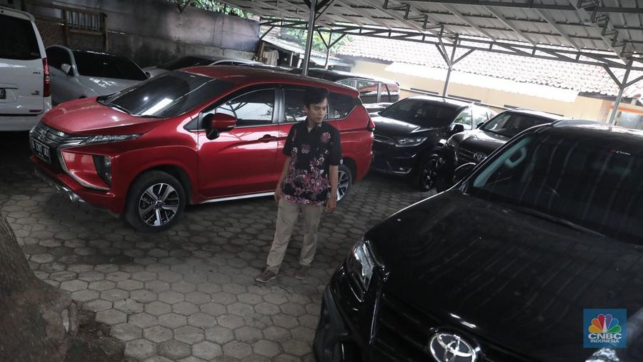 Pekerja  mengecek kendraan yang akan di rentalkan di pool penyewaan rental mobil Sembodo Rentcar di Kawasan Jakarta, Rabu, (13/4/2022). (CNBC Indonesia/ Muhammad Sabki)