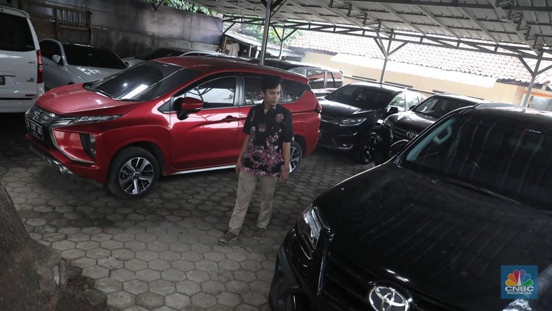 Pekerja  mengecek kendraan yang akan di rentalkan di pool penyewaan rental mobil Sembodo Rentcar di Kawasan Jakarta, Rabu, (13/4/2022). (CNBC Indonesia/ Muhammad Sabki)