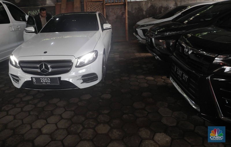 Pekerja  mengecek kendraan yang akan di rentalkan di pool penyewaan rental mobil Sembodo Rentcar di Kawasan Jakarta, Rabu, (13/4/2022). (CNBC Indonesia/ Muhammad Sabki)
