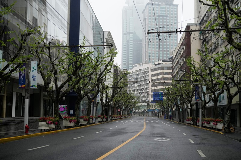 Kondisi Jalan Kosong di Shanghai China Saat Lockdown Seorang warga terlihat di balik pembatas yang menutup area yang dikunci di tengah pandemi penyakit virus corona (COVID-19), di Shanghai, China, Kamis (14/4/2022). (REUTERS/Aly Song)