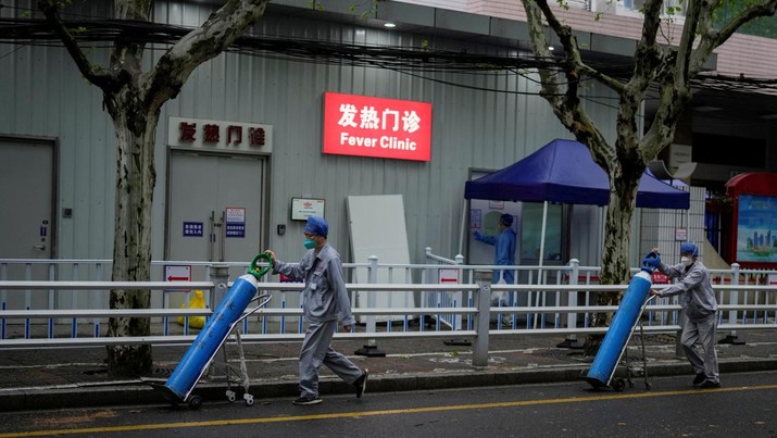 Pekerja mengirim tabung oksigen di luar rumah sakit selama penguncian di tengah pandemi penyakit coronavirus (COVID-19), di Shanghai, China, Kamis (14/4/2022). (REUTERS/Aly Song)