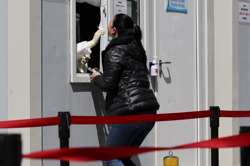 Kondisi Jalan Kosong di Shanghai China Saat Lockdown Seorang warga terlihat di balik pembatas yang menutup area yang dikunci di tengah pandemi penyakit virus corona (COVID-19), di Shanghai, China, Kamis (14/4/2022). (REUTERS/Aly Song)