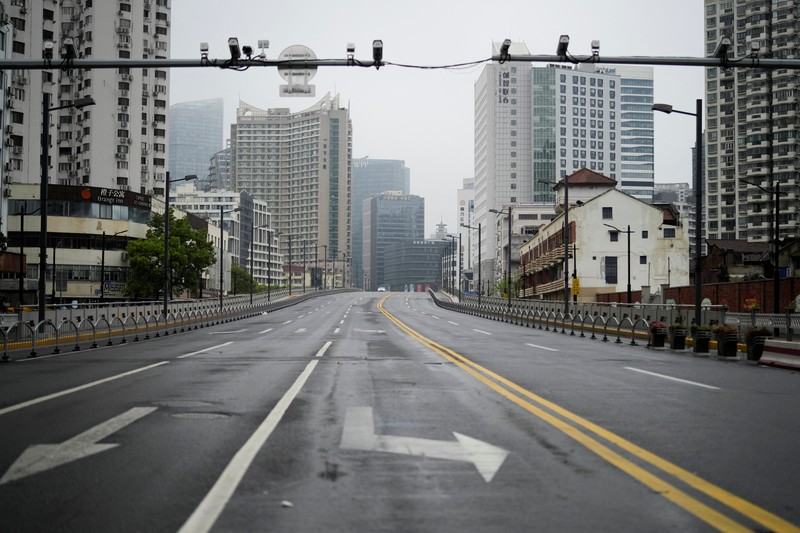 Kondisi Jalan Kosong di Shanghai China Saat Lockdown Seorang warga terlihat di balik pembatas yang menutup area yang dikunci di tengah pandemi penyakit virus corona (COVID-19), di Shanghai, China, Kamis (14/4/2022). (REUTERS/Aly Song)